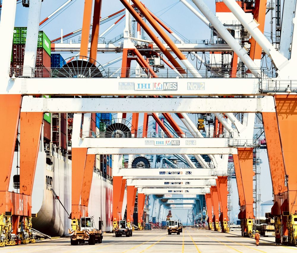 Orange gantry cranes above a container terminal